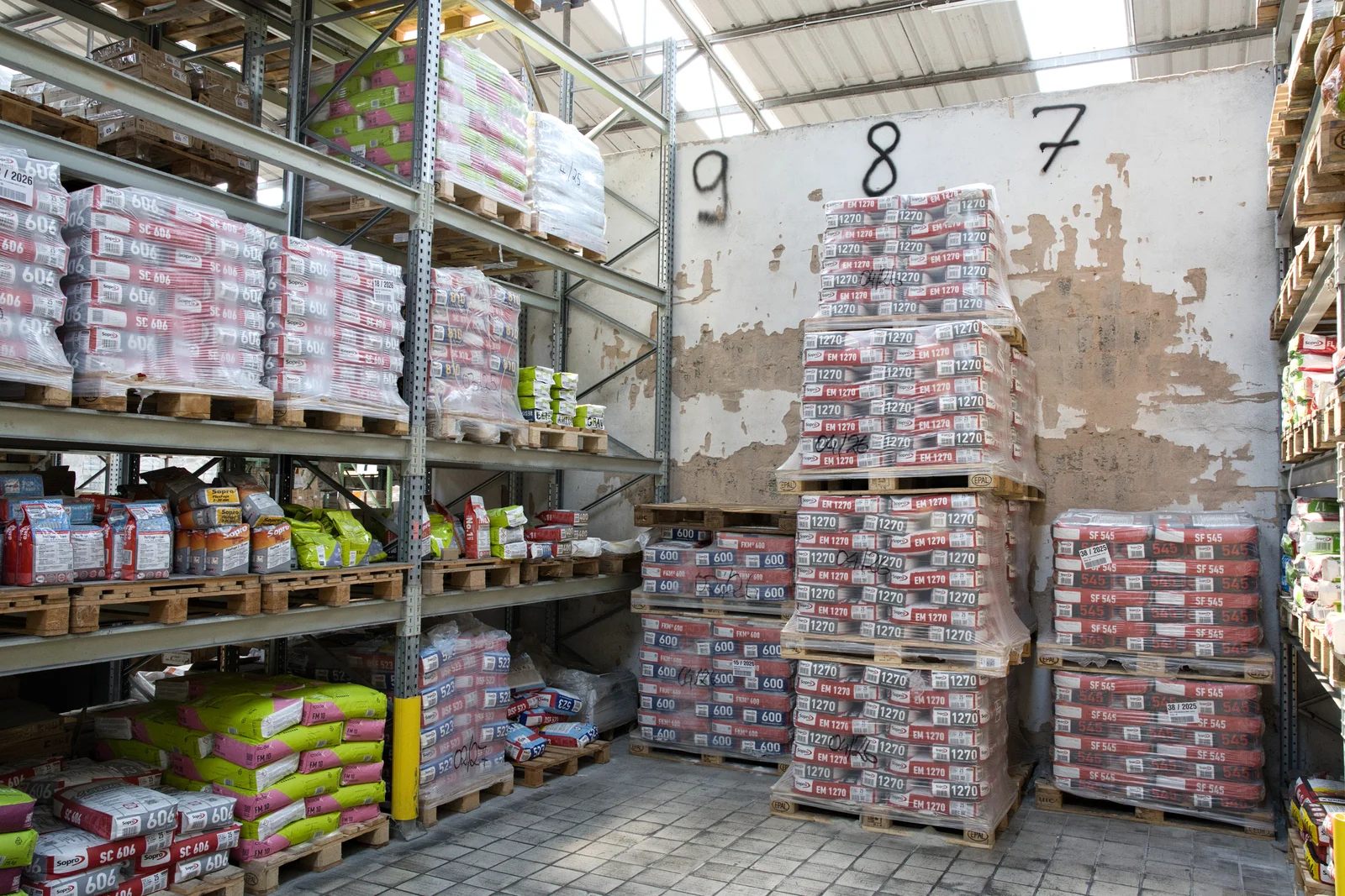 Paletten mit Fliesenkleber und Baustoffen im Lager von Vatter